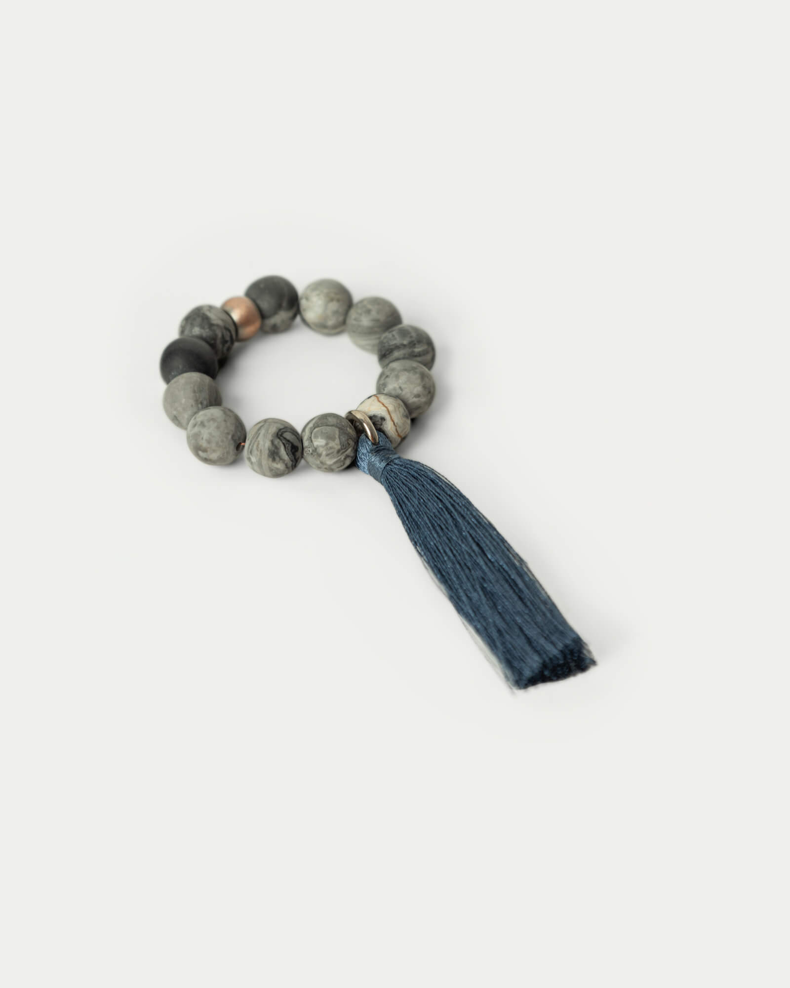 Obrączka na serwetkę z naturalnych kamieni szarego jaspisu i niebieskim chwostem.